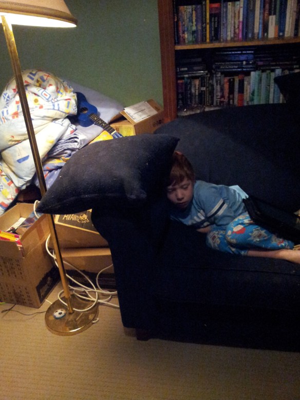 My 7yo watching TV in our lounge room. See? This is the pile of stuff we still need to sort out. It happens. We'll get there. 